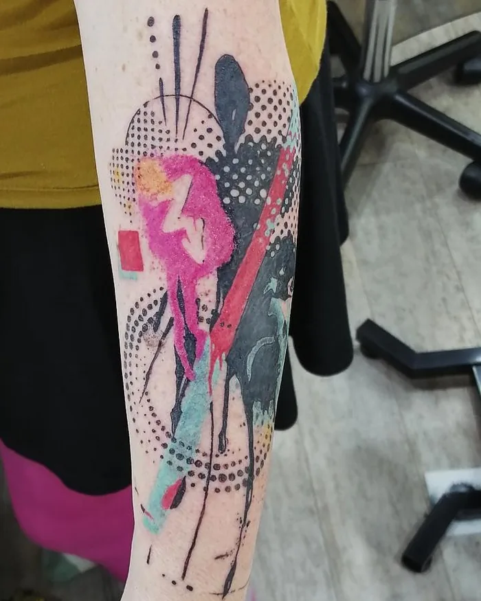 Composition abstraite en couleur — trame de points, éclats rose et rouge — tatouée sur un avant-bras